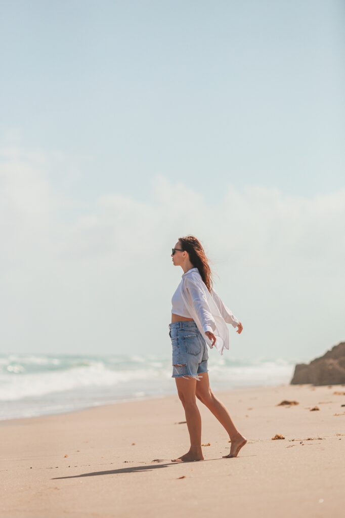 Young happy woman on the beach enjoy her summer vacation. Girl is happy and calm in her stay on the