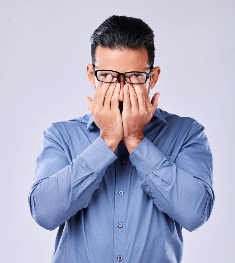 Stress, headache and man with glasses in studio for vertigo, eye strain or blurry vision on grey ba